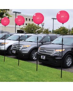 Premium Reusable Pink Balloon Ground Pole Kit on poles in front of an auto dealership