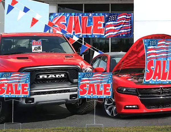 sale banners, curb signs and hang tags at a car dealership